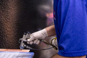 DECC Spray gun specialist coating parts manually with dielectric coating.