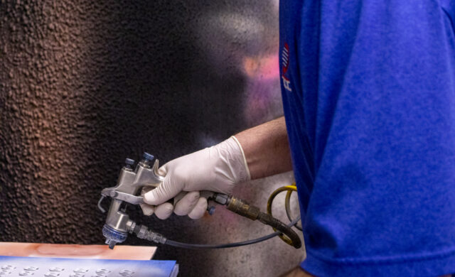 DECC Spray gun specialist coating parts manually with dielectric coating.