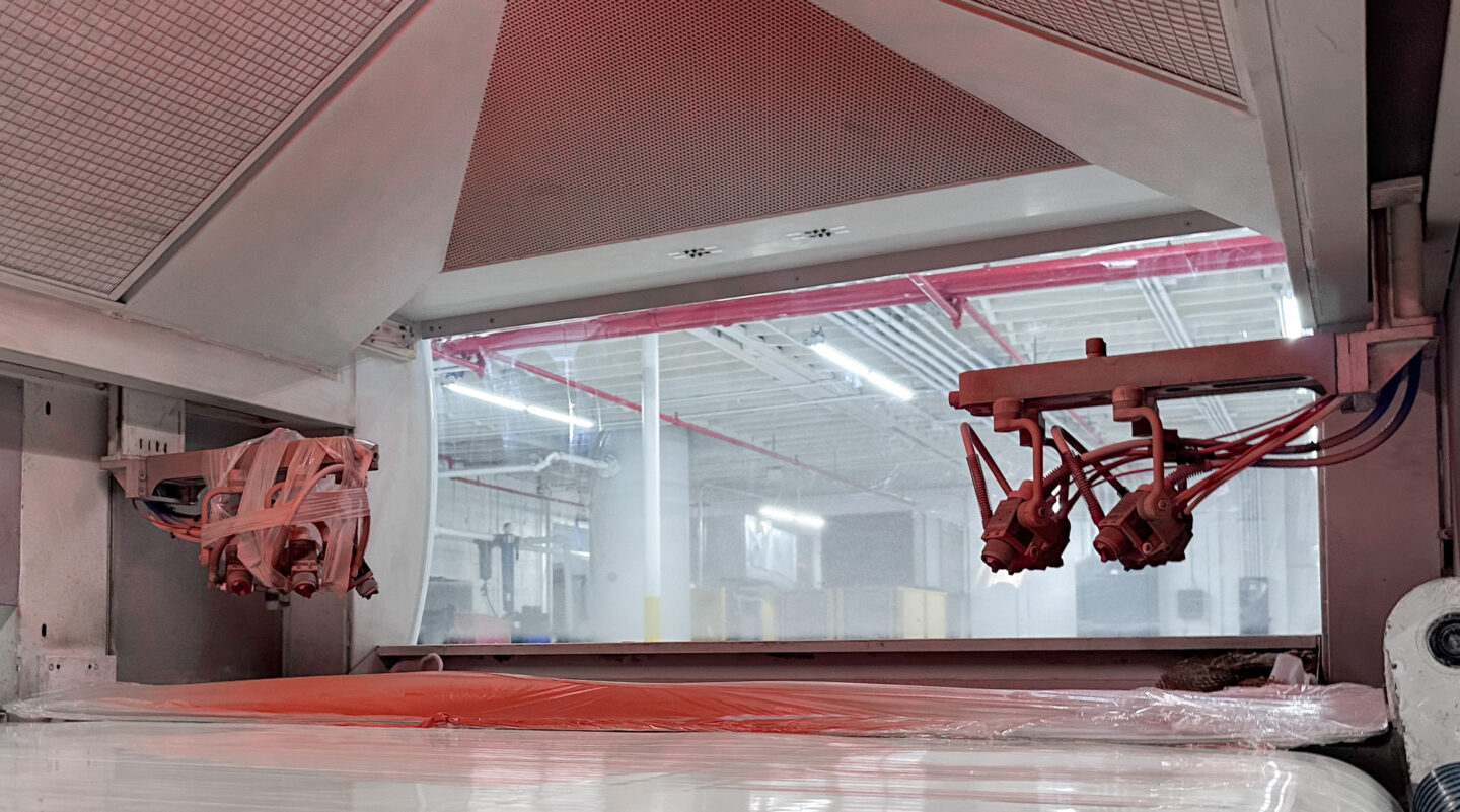 Two parallel spray guns for flatline system to coat parts as they go through the spray chamber.